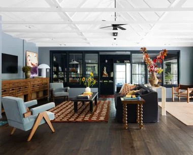An eclectic living area with a raised open ceiling and vintage style furniture.