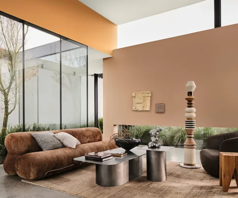Living room featuring warm browns and terracottas with chrome coffee and side tables.