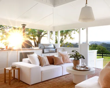 The outdoor living area with a white raised ceiling and sofas.
