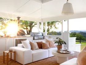 The outdoor living area with a white raised ceiling and sofas.
