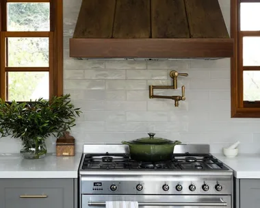 green cast iron pot on stove top with brass pot filler