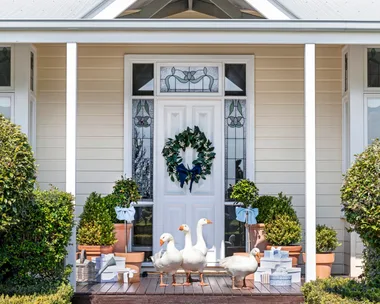 The outdoor white Hamptons style entrance with geese on the steps.