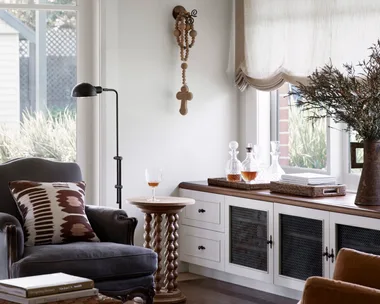 Cottage living room with Austrian blinds and build in cabinetry
