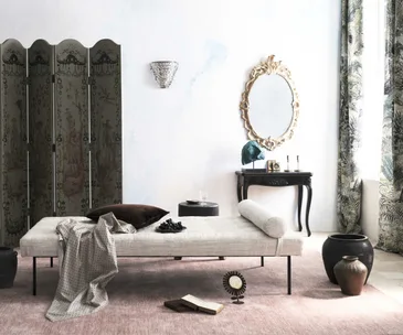 Elegant living room with a chaise longue, ornate mirror, decorative screen, and various decor items arranged tastefully.