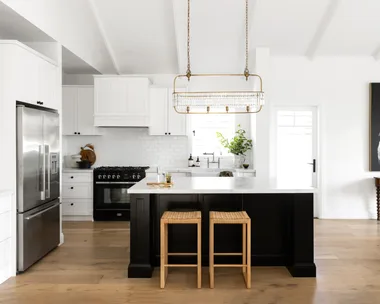 A white and black Hamptons style kitchen with raised ceilings.
