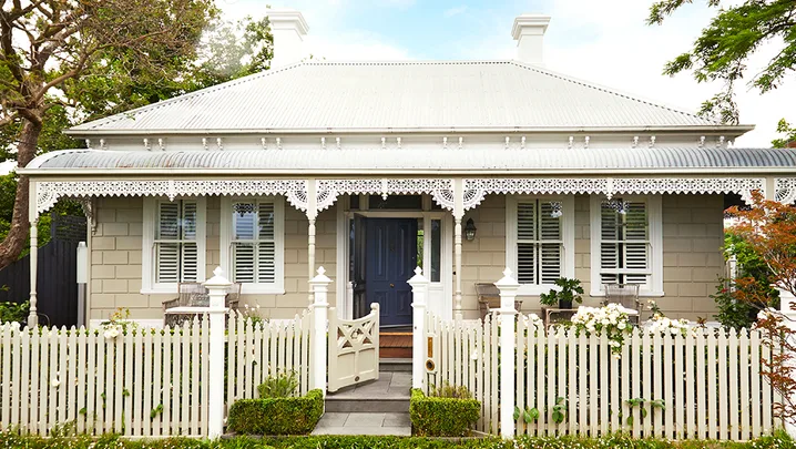 A heritage home with a white facade and picket fence.