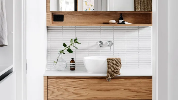 A white and timber ensuite with white finger tiles.
