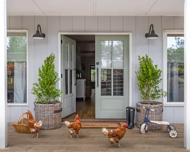 A modern farmhouse with chickens outside.