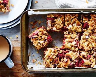 oat slice recipe in a tray with a cup of tea beside it
