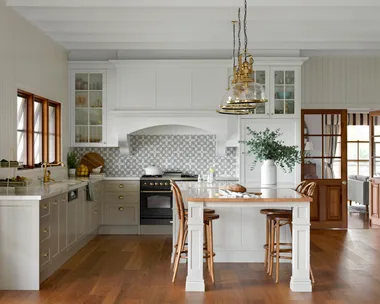A country kitchen with blackbutt timber floors, a timber topped table and brass accents.