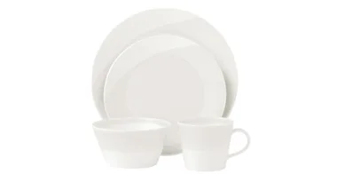 A white dinnerware set with two plates, a bowl, and a mug on a white background.