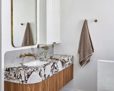 A white bathroom which showcases small bathroom design ideas, such as recessed storage.