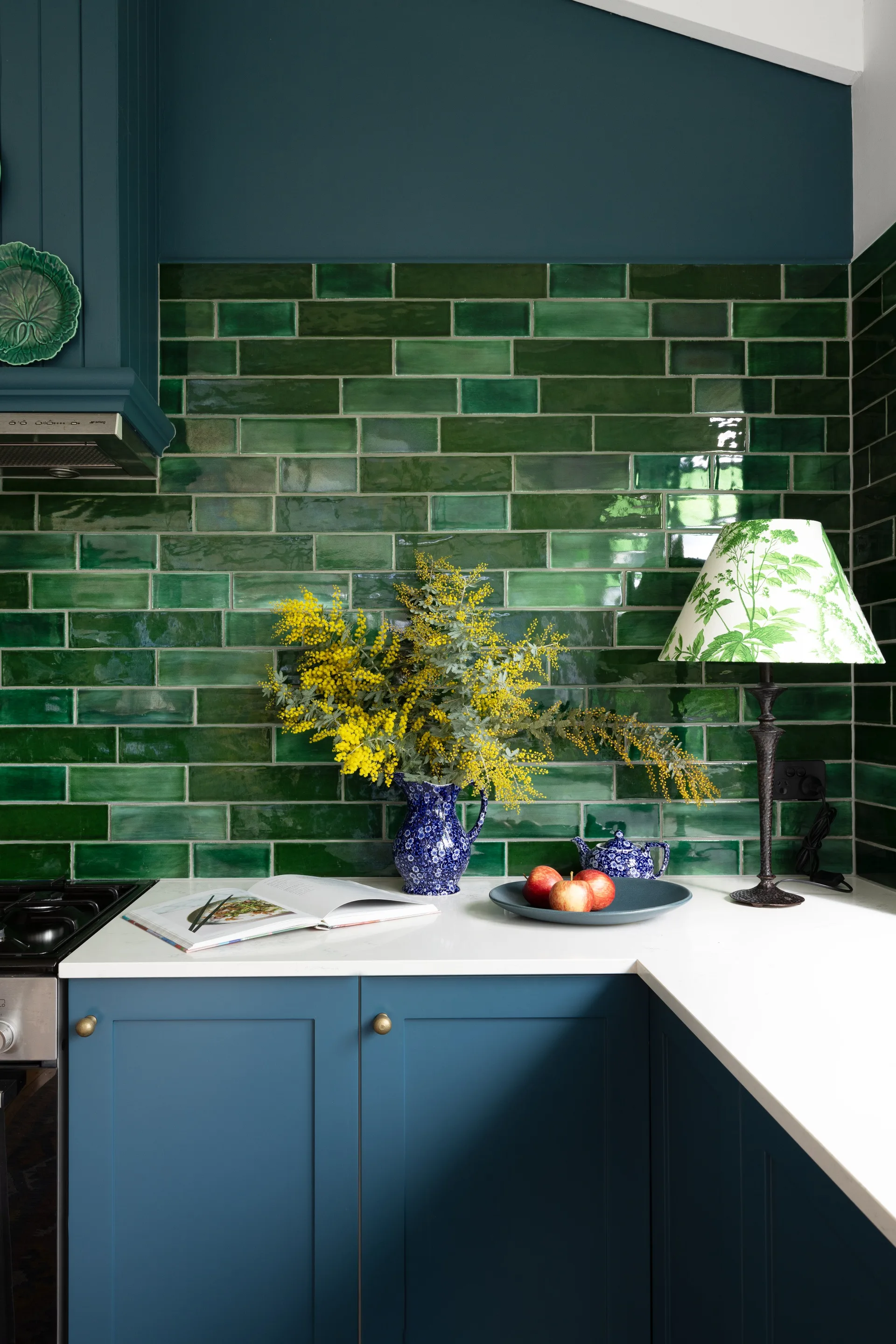 A green subway tile splashback above turquoise cabinets in the kitchen.