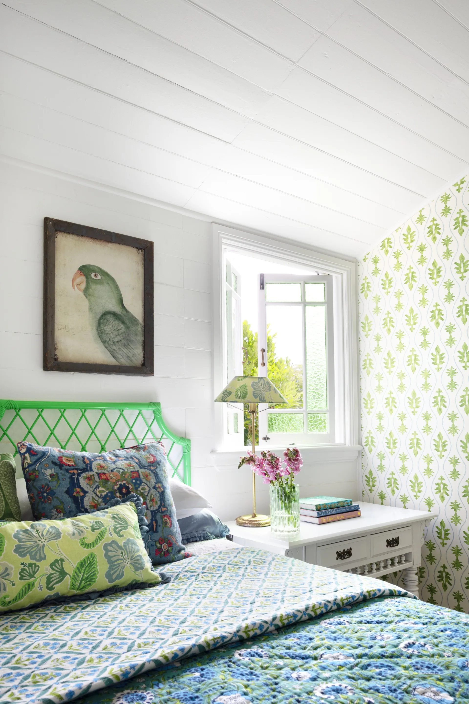A bright cottage-style guest bedroom with a vintage quilt.