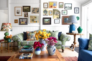 A vintage-style living area with a green sofa and gallery wall.