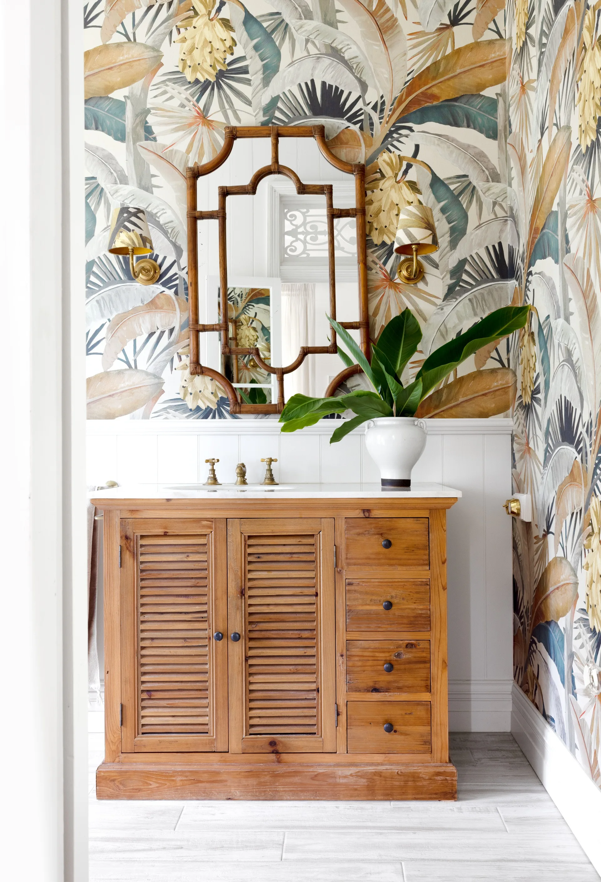The main bedroom ensuite with palm leaf wallpaper and a timber vanity.