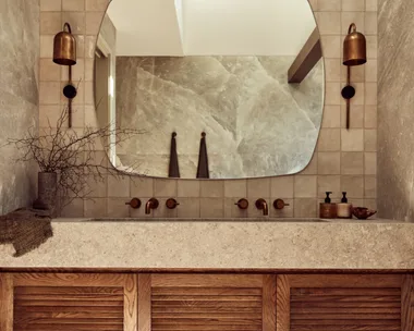 A main bathroom with rock salt tiles and a wooden floating vanity topped with stone.