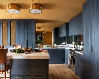 A yellow and dark blue kitchen with timber floors.