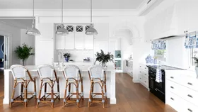 white hamptons kitchen with bar stools and 3 silver pendant lights