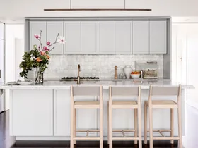 Kitchen with grey cabinetry and a vase of flowers on the island.