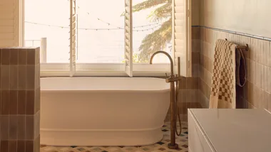 white acrylic freestanding bathtub in a warm bathroom