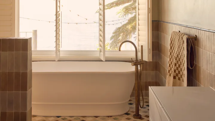 white acrylic freestanding bathtub in a warm bathroom