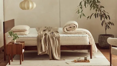 A side image of a bed with all bedding essentials including pillows, mattress, quilt and blanket for a good night's sleep